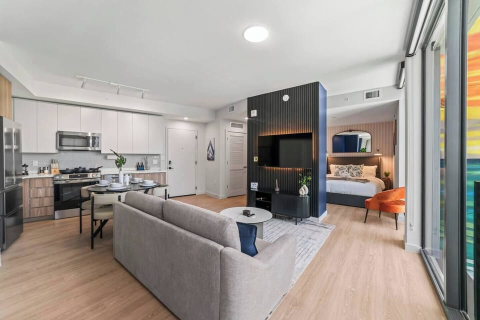 Stylish open-concept suite with full kitchen, TV lounge, and bright modern design