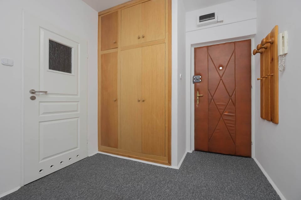 The entrance hall includes the apartment door, wardrobe, and a coat rack. The space is tidy and convenient.