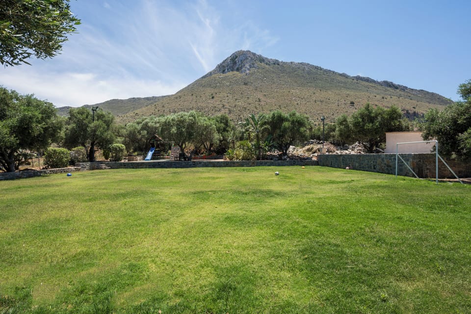Expansive lawn framed by mountain views and lush greenery, offering a peaceful setting for outdoor relaxation.