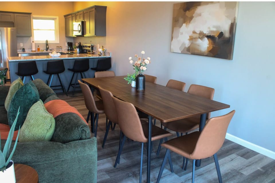 Gather around this spacious dining table with seating for eight, perfect for your morning coffee or evening meals with loved ones. The open layout connects you to the fully equipped kitchen, making entertaining effortless and enjoyable.