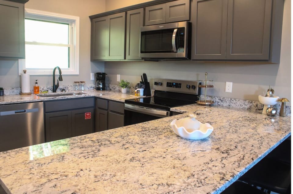You'll love preparing meals in this bright, modern kitchen with sleek granite counters, stainless appliances, and all the essentials you need for a comfortable stay.
