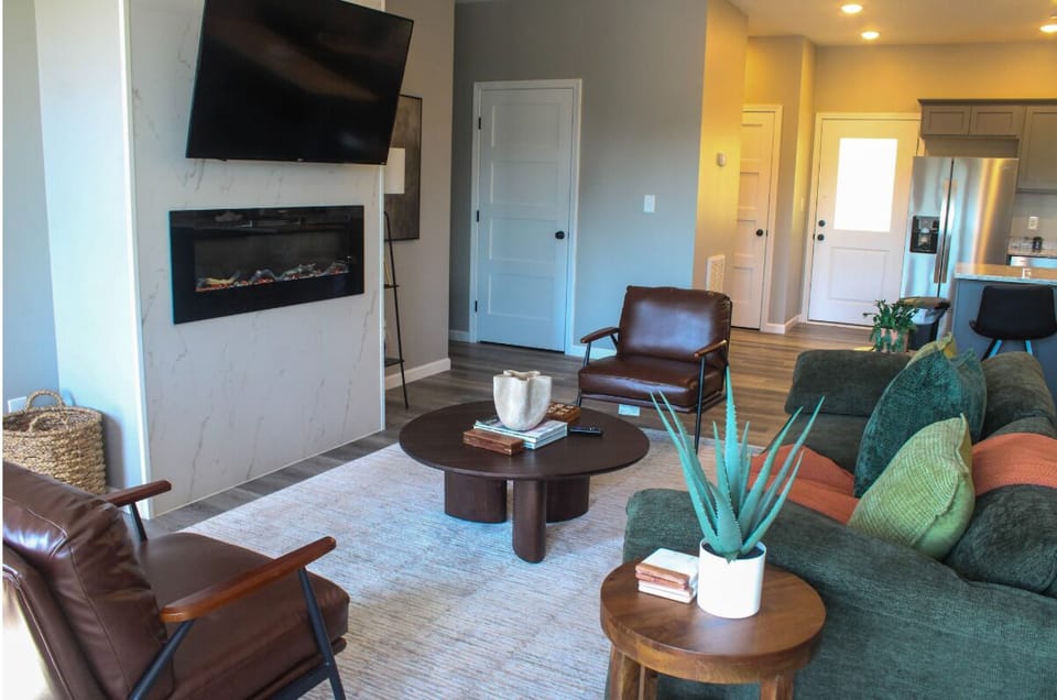 Unwind in your stylish living space with a cozy fireplace, modern furnishings, and an open layout that flows seamlessly into the kitchen.
