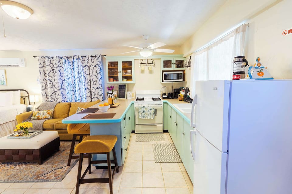 Full kitchen with breakfast bar seating, open to living area