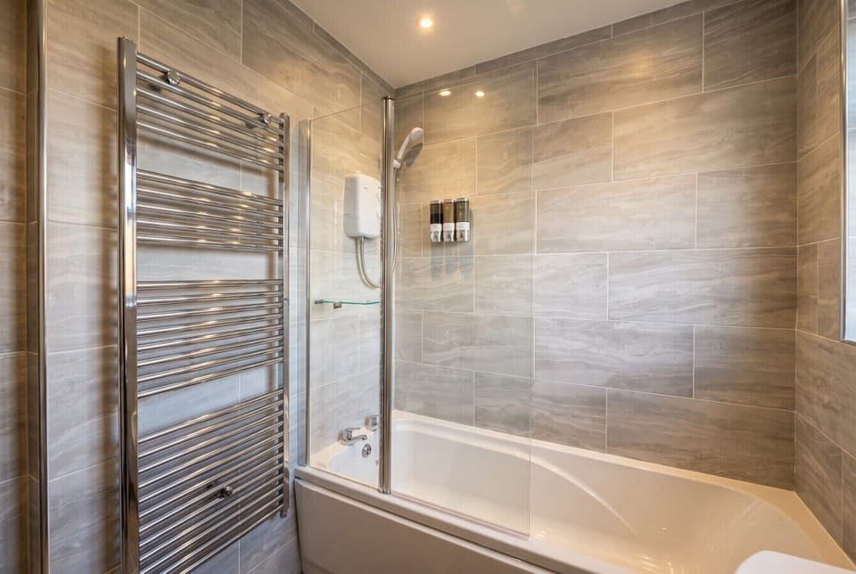 Spa style bathroom with heated towel rail and a relaxing bath and shower