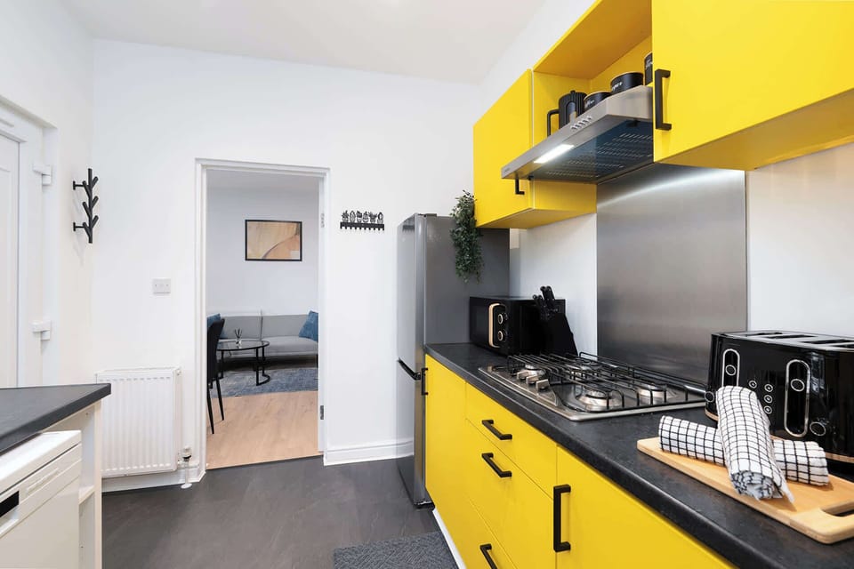 Vibrant modern kitchen with all essential appliances and space to prepare meals, ideal for long-term guests and working professionals.