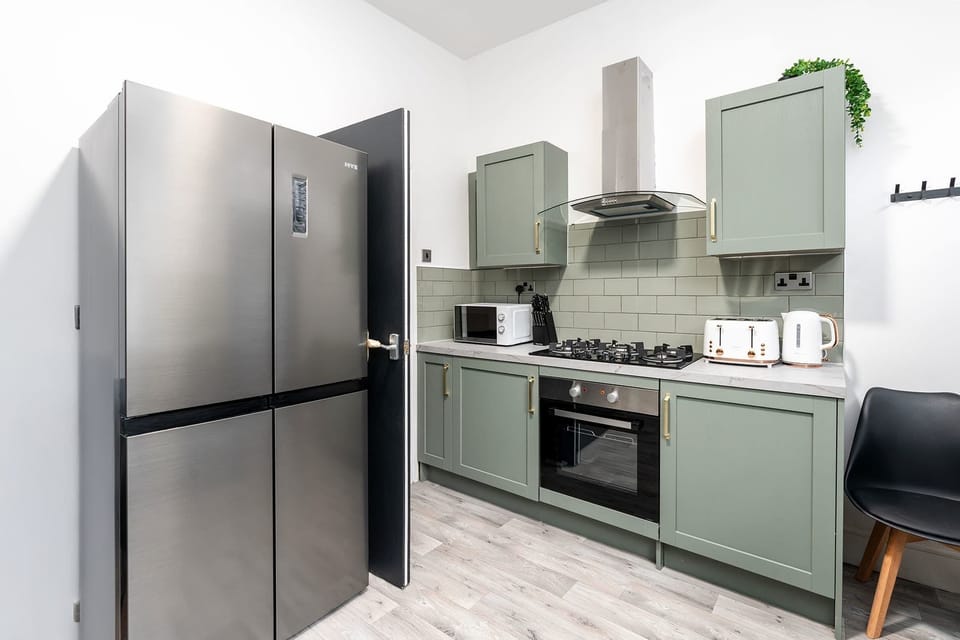 A clean, modern kitchen with full-size appliances and clear worktop space, suitable for preparing everyday meals.