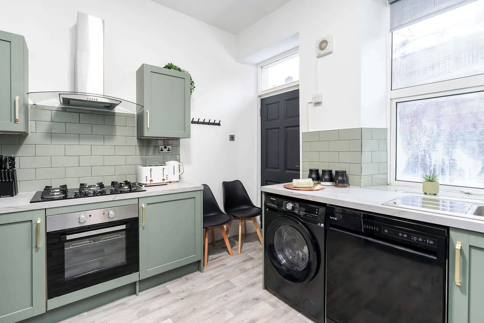 A clean, modern kitchen area with integrated appliances and seating, designed for everyday use and ease.