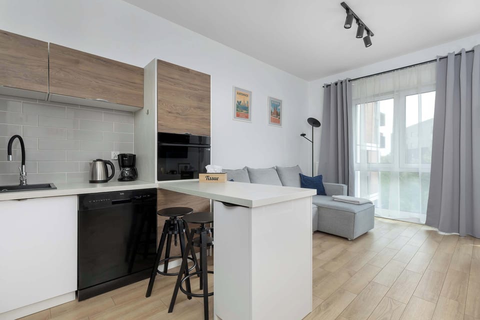 Modern kitchen with white cabinets, wooden accents, kitchen island, and built-in appliances.