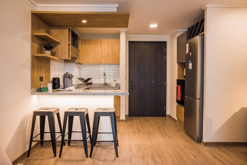 Cozy and modern kitchen with stylish bar seating, perfect for enjoying a meal or morning coffee.