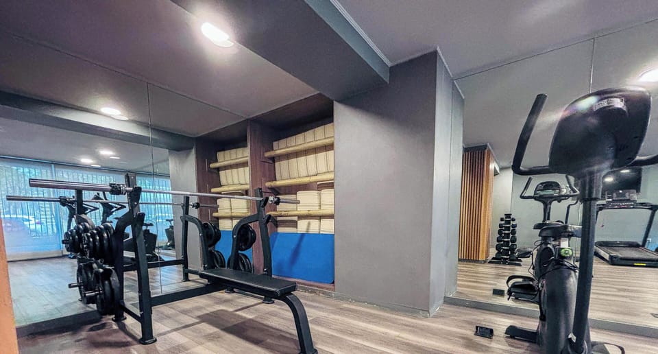 Private mini gym with weights, bike, and mirrored workout space