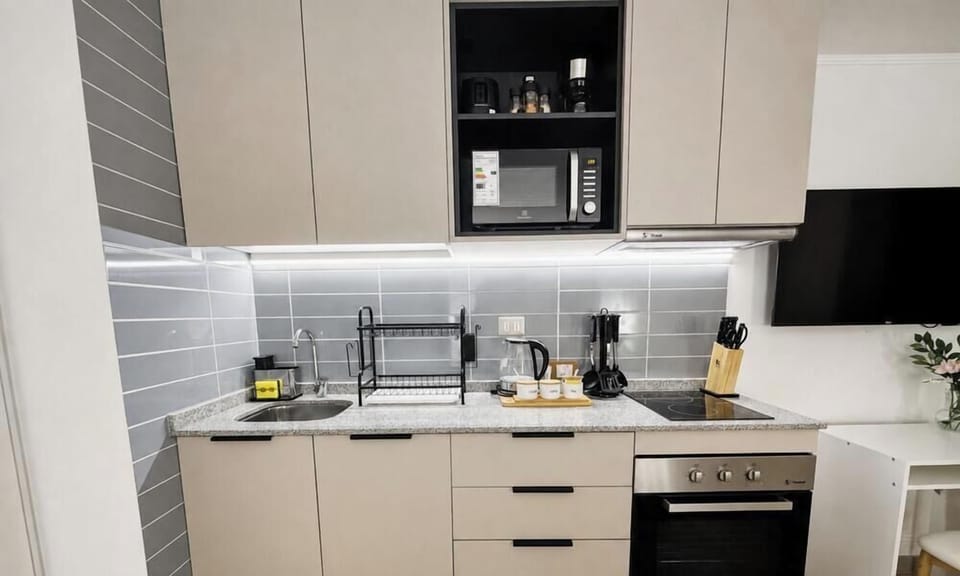 Modern, well-equipped kitchenette with oven, microwave, and coffee setup