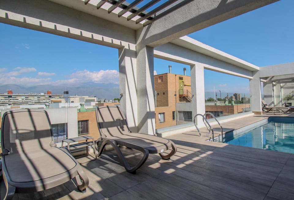 Sunny rooftop pool with lounge chairs and relaxing city views