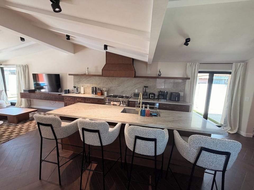 Entertain with ease in this bright, open-concept kitchen featuring premium appliances and a large social island. Large sliding glass doors invite the outdoors in for a light-filled dining experience.