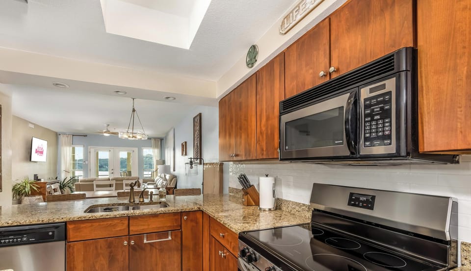 Full-size kitchen with stainless appliances, granite countertops, and open sight into the living area. Perfect for family gatherings