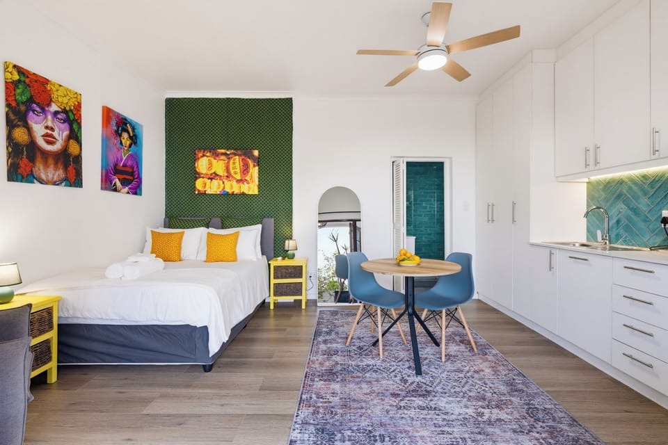 Bright modern studio with bold decor, dining nook, and sleek kitchenette