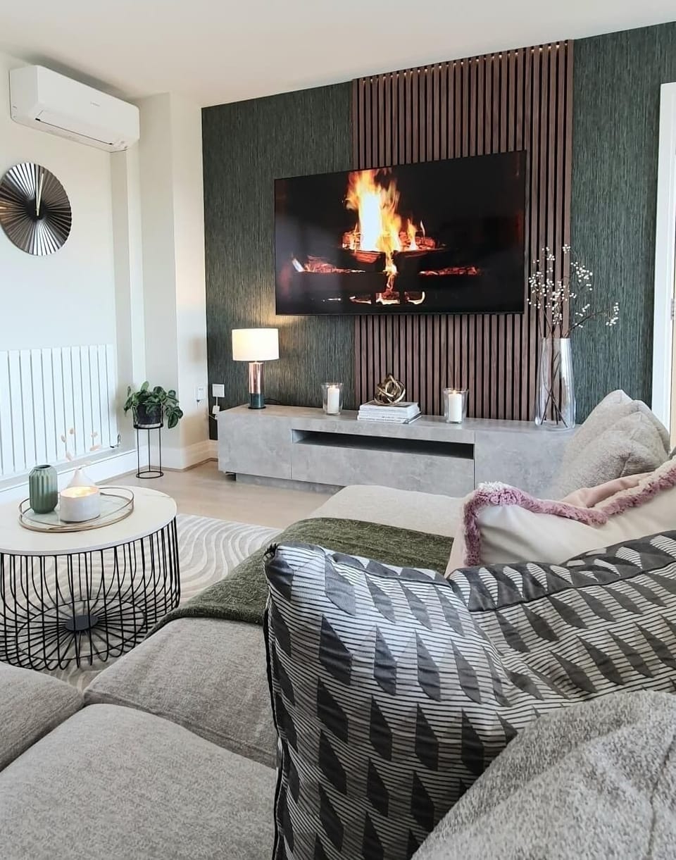 The comfortable living room features an L-shaped sofa and smart TV