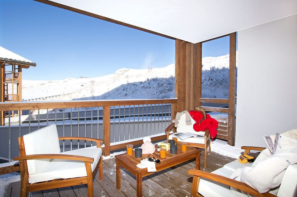 East-facing terrace catches the morning sun over the Alpe d'Huez peaks, with room for coffee.