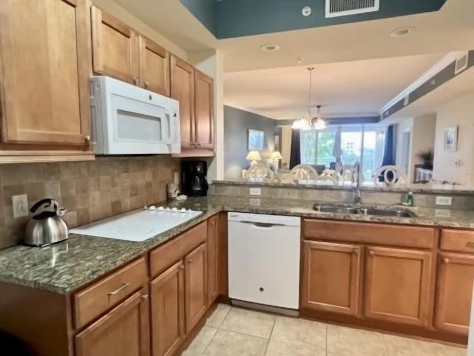 Kitchen with rich wood cabinetry, granite counters, and full-sized stainless appliances