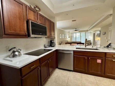 Kitchen with dark wood cabinetry, granite counters, and full-sized stainless appliances