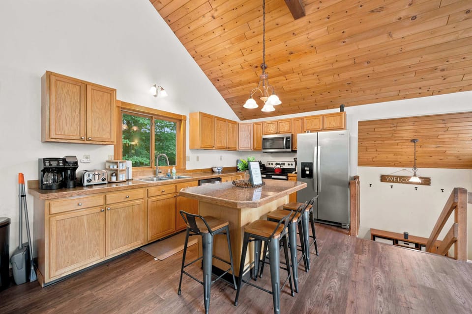 The full kitchen has wood cabinetry, stainless appliances, and an island with bar seating for four.