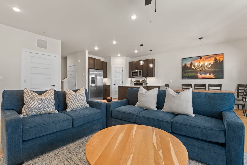 Sink into plush sofas and unwind in your open-concept living space, where modern style meets mountain comfort. The fully equipped kitchen flows seamlessly into your dining and relaxation areas, perfect for gathering after a day of adventure.