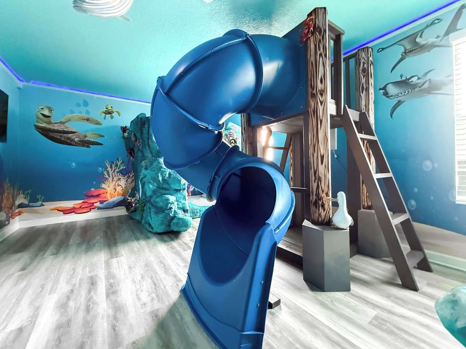 The Great Barrier Reef Retreat (Finding Nemo Themed) (Sleeps 4). An extraordinary underwater adventure featuring: 🪸 2 Coral reef-inspired bunk bed structures, a large circular slide in the center of the room and more. 