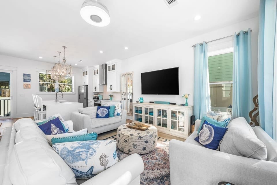 Beach house retreat with modern open-concept living. Relax in a sun-drenched lounge featuring an extra-large Smart TV and premium soundbar. . The space flows into a chef’s island kitchen with modern appliances and a breakfast bar, 