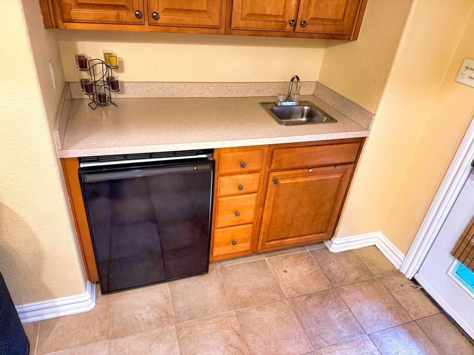 Cozy kitchenette with mini-fridge, sink, and ample storage