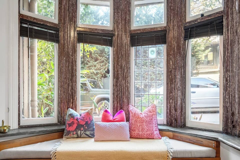 Ease into the morning with coffee on the cushioned bay window seat, surrounded by soft light and leafy outlooks—your own quiet moment in the heart of the city.