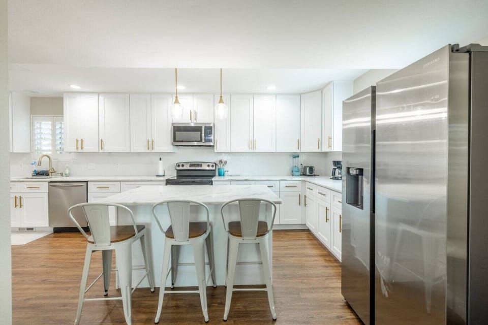 Modern white kitchen with stainless steel appliances and island seating