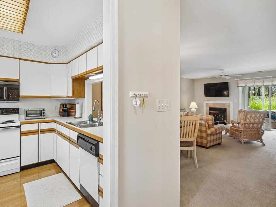 Open-plan kitchen and dining area with white cabinetry, full appliances, and seating for the whole group