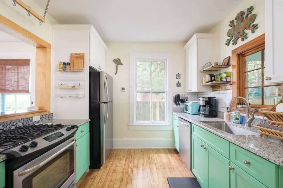 Full kitchen with 4 burner gas stove, microwave, water filter on the sink and fun art