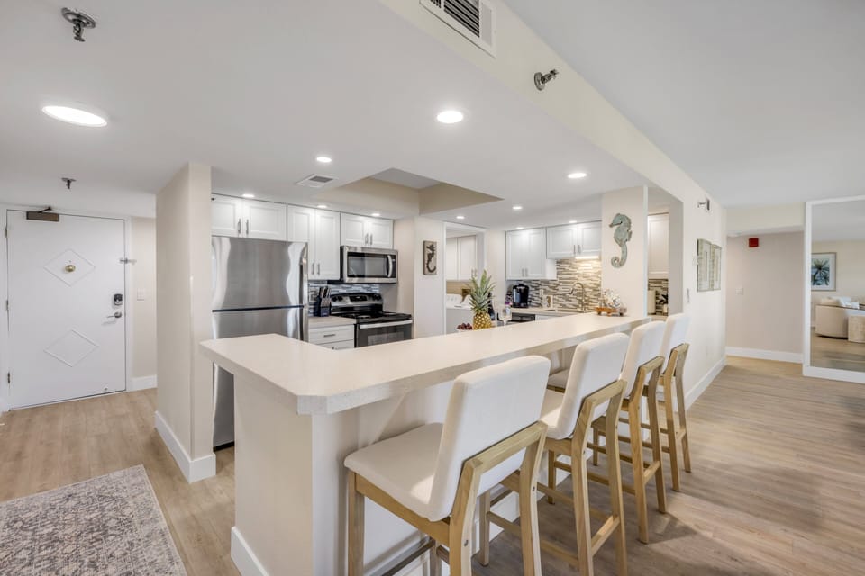 Cook and gather in The Ormondy Unit B7's light and airy updated kitchen, featuring modern appliances and a fully equipped space for effortless coastal living