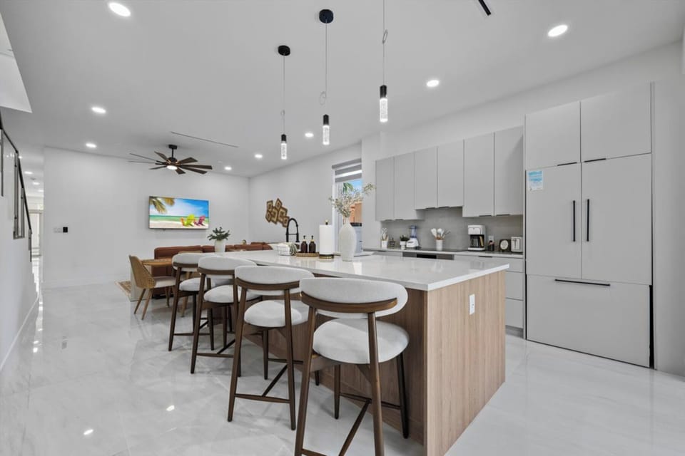 Kitchen island breakfast bar with barstool seating open to living area.