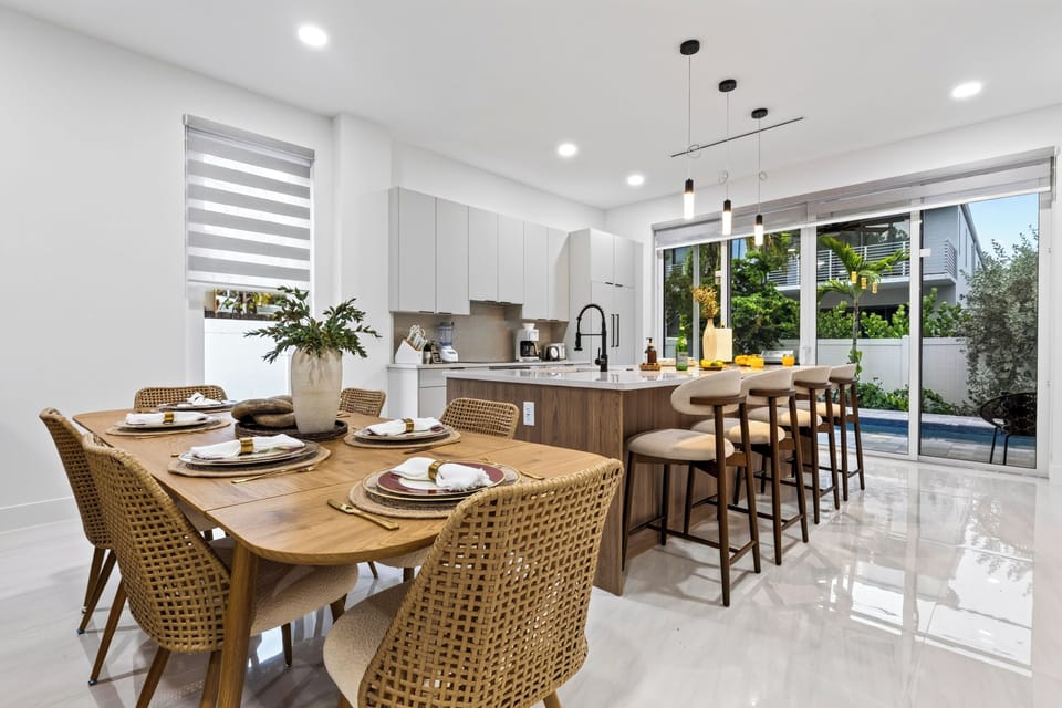 Indoor dining opens toward the kitchen and pool, making every meal feel relaxed and connected.