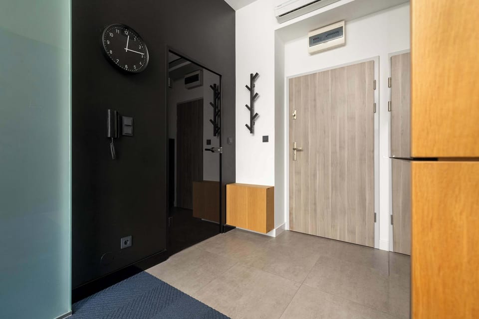 A stylish entryway, with s wooden door and a sleek, modern bench complete the welcoming space.
