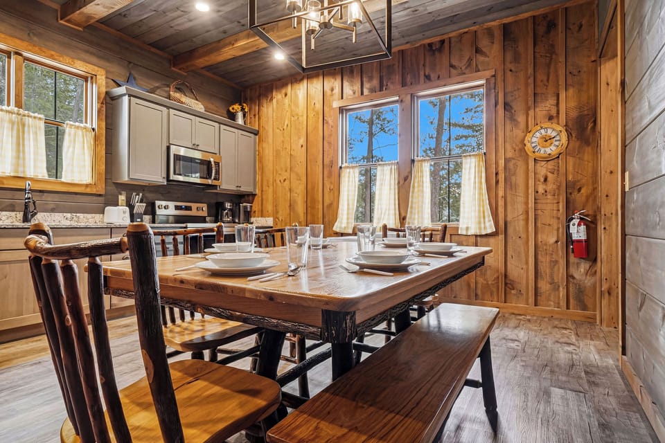 Step into your cozy cabin retreat where rustic wood beams and warm lighting create the perfect gathering space for memorable meals with loved ones.