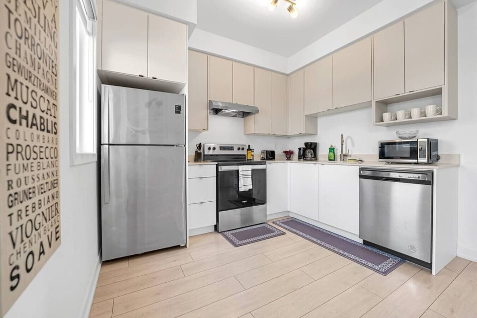 A kitchen area showcasing stainless steel appliances alongside a decorative wall graphic featuring wine types—great for planning a wine-tasting night or cooking a gourmet dinner.