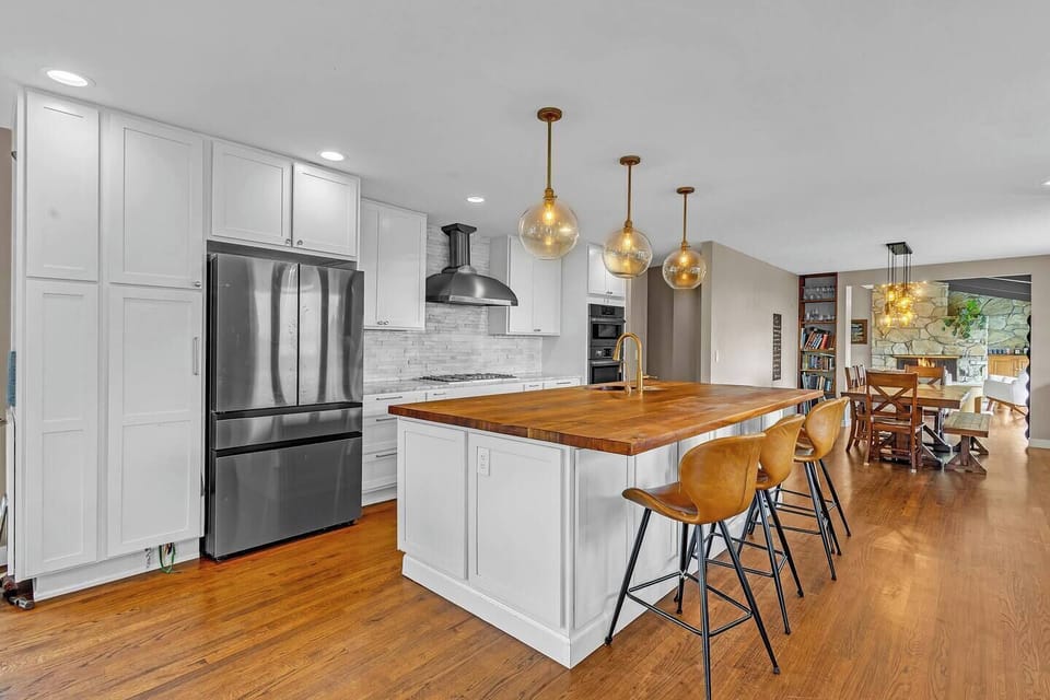 Fully equipped for long-term stays with premium built-in double ovens, a commercial-grade range hood, a deep sink, and plenty of cabinet storage for all your family groceries.