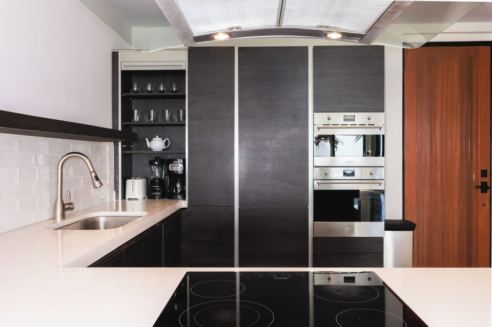 Brew morning coffee with sleek built-ins and glassware ready.