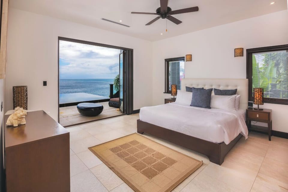 Unwind in crisp linens with breezy oceanfront terrace access.