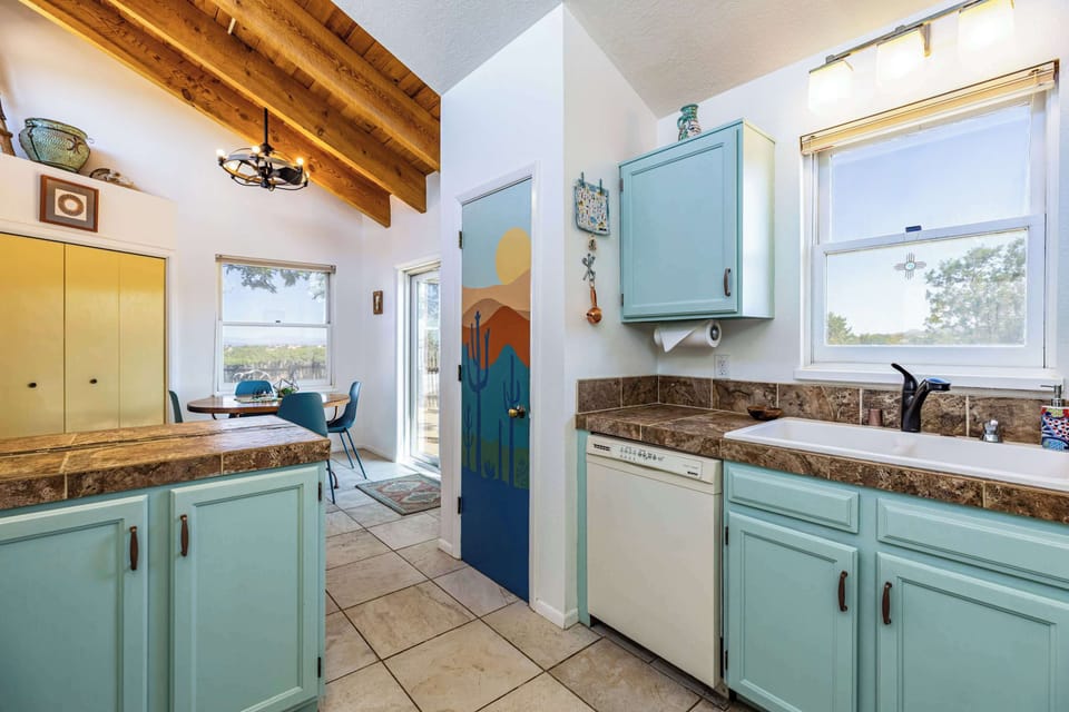 Gather in the kitchen and dining area beneath exposed wood beams