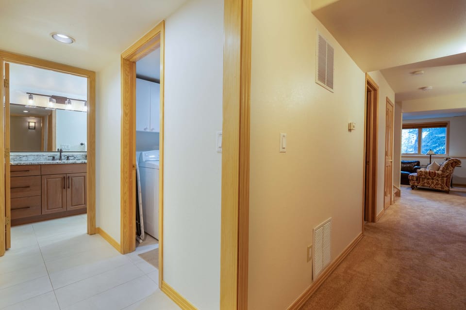 The lower-level hallway connects the bedrooms, bathrooms, laundry room, and family room