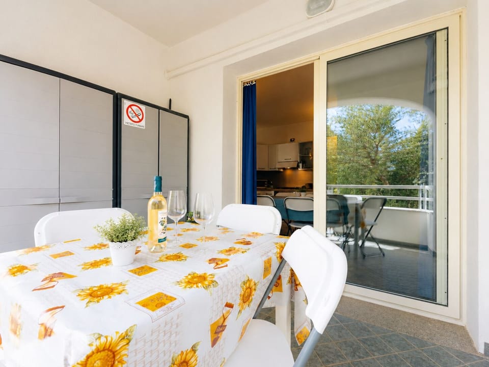 Private covered balcony with outdoor dining and peaceful green views
