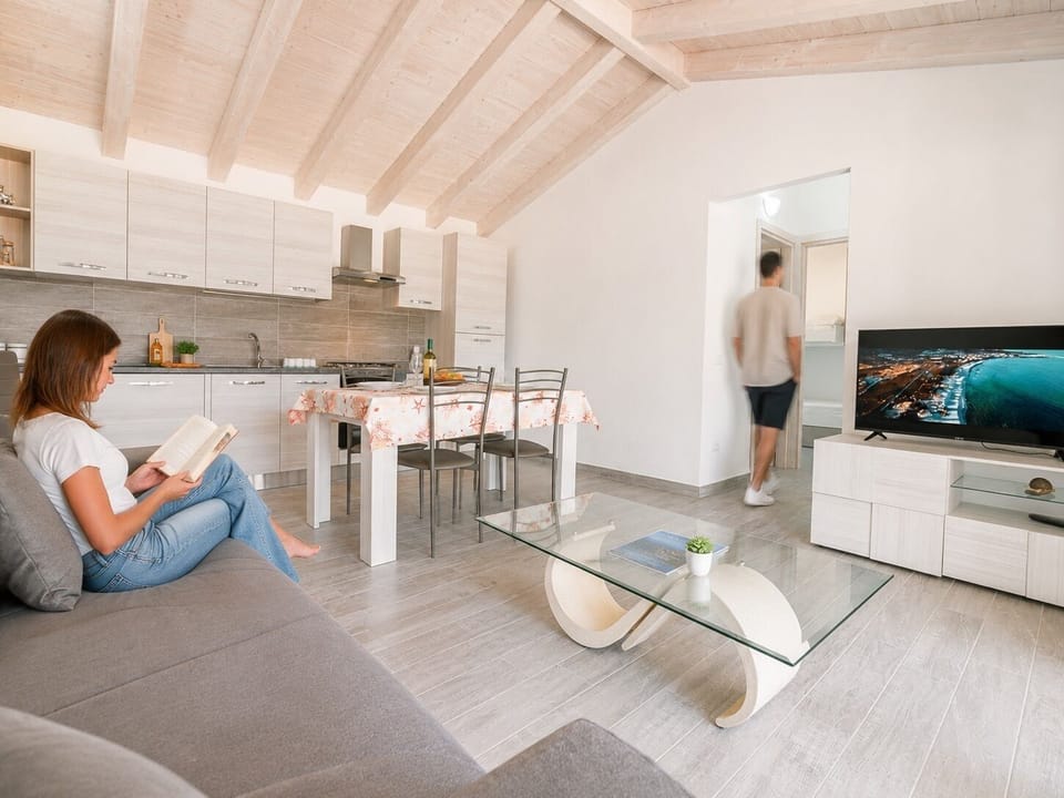 Bright open-plan living area with modern kitchen and vaulted wood ceiling