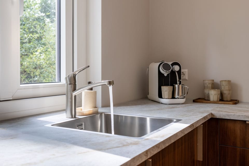 Bright kitchen nook with window light, modern sink, and coffee station