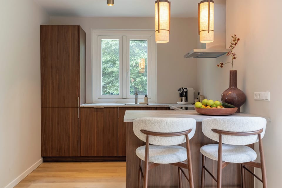 Stylish modern kitchen with breakfast bar, pendant lights, and garden views