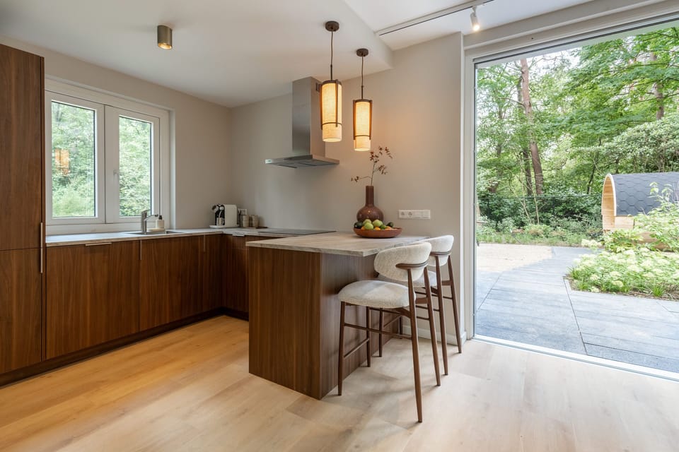 Bright modern kitchen with island seating and serene garden views