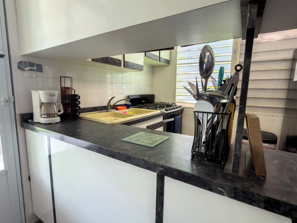 Bright, well-equipped kitchen with gas range, coffee maker, basic utensils to prepare meals