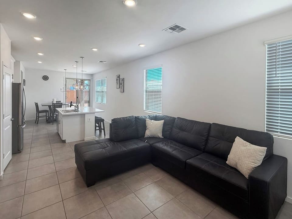 Living room with sectional sofa and window blinds